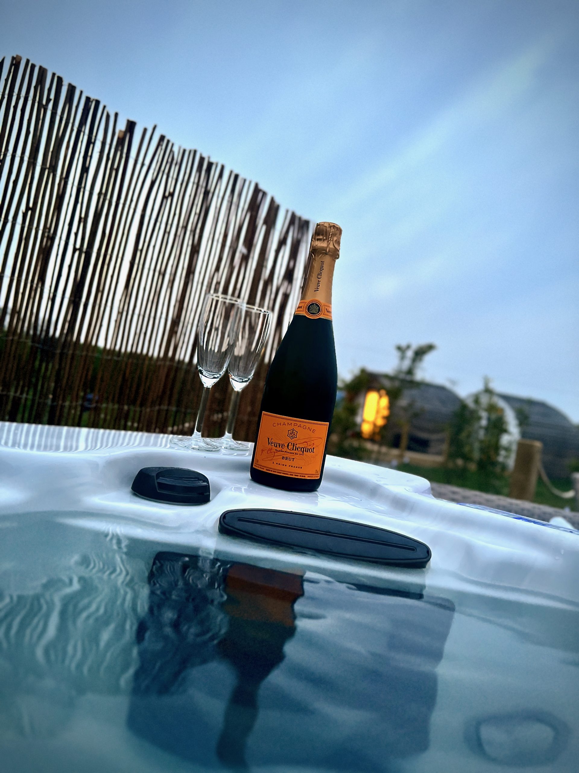 Bottle of Champagne at the side of a hot tub 
