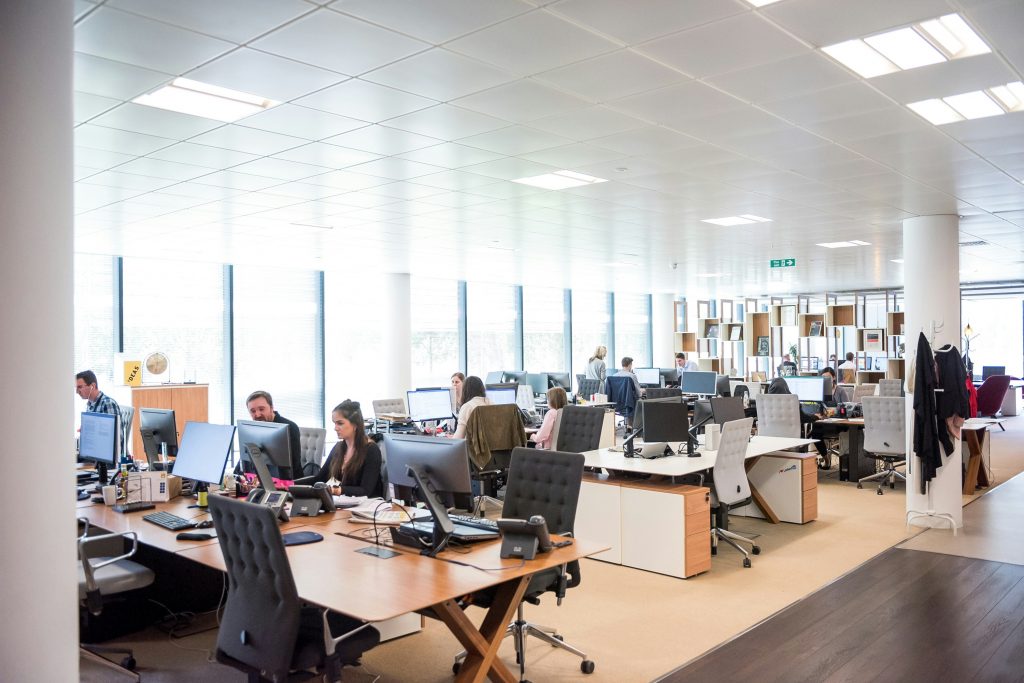 Modern office space with employees working at desks equipped with computers and telephony systems, symbolizing streamlined communication and integration in a business environment.