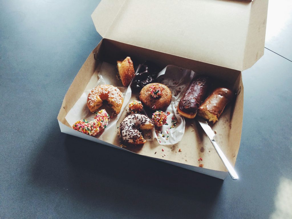 Part eaten doughnuts in a box