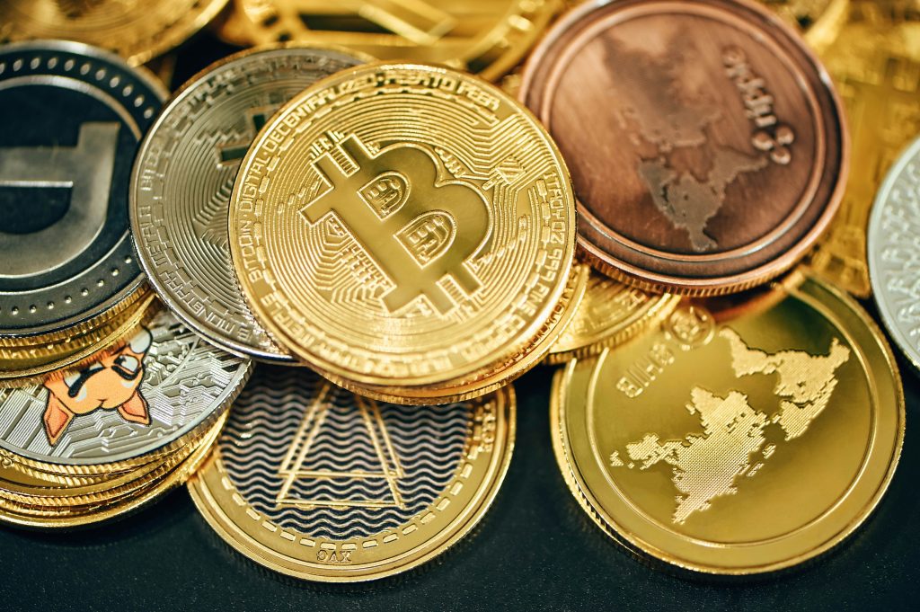 A close-up view of various cryptocurrency coins, including Bitcoin, displayed in a stack. The image showcases the physical representations of digital currencies, emphasizing blockchain technology and financial innovation.