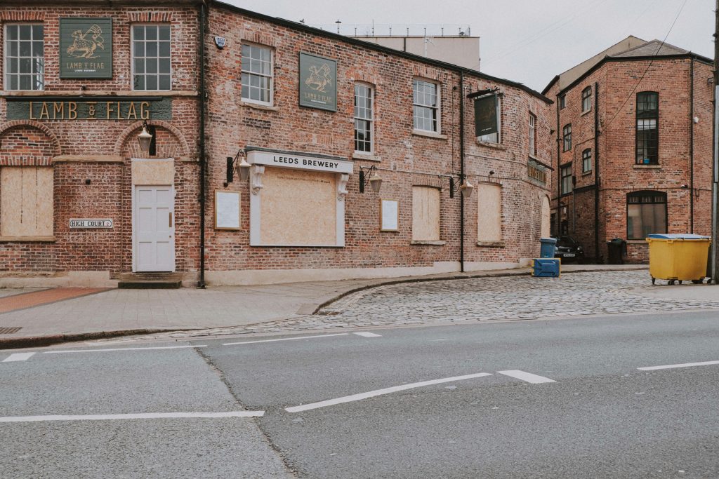 Boarded-up traditional British pub on a quiet street, symbolising the decline of pub culture in the UK.
