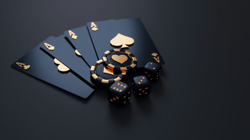 A sleek, dark-themed image featuring four black playing cards (all aces), two black-and-gold poker chips, and four black dice with gold dots, arranged on a dark surface to create a luxurious and high-stakes casino feel.