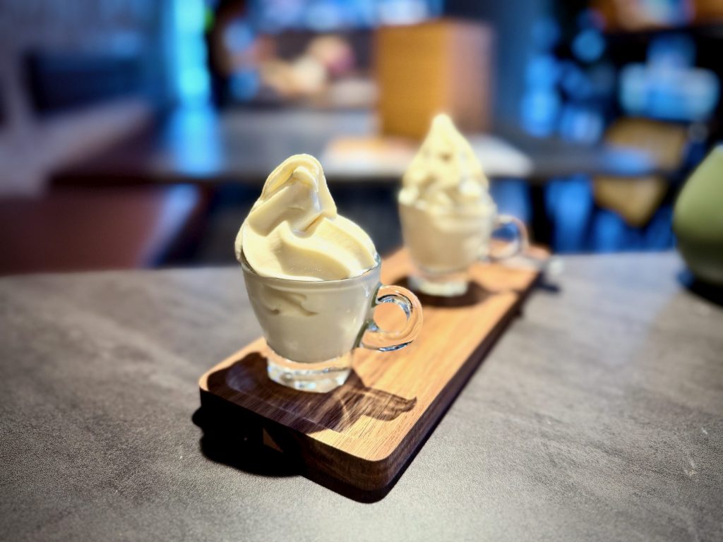 Two espresso cups filled with soft-serve ice cream on a wooden board, served as dessert at Nesso Leeds.