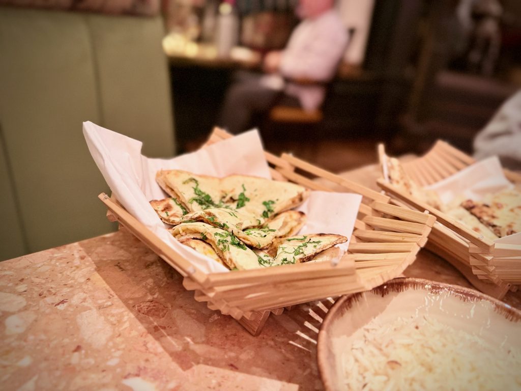 Fluffy garlic and coriander naan served at Cinnamon Kitchen Leeds – golden, fragrant, and ideal for scooping rich curries