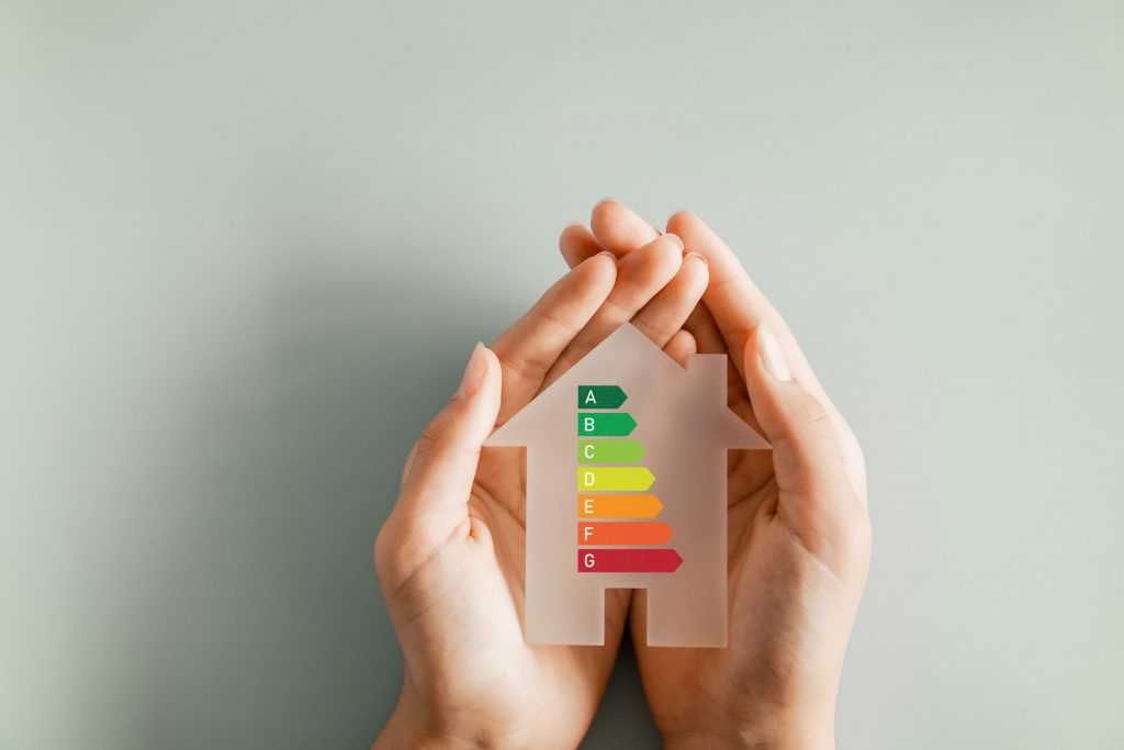 Hands holding a house cut-out showing an EPC energy efficiency rating scale from A to G, representing ECO4 upgrades in Yorkshire.