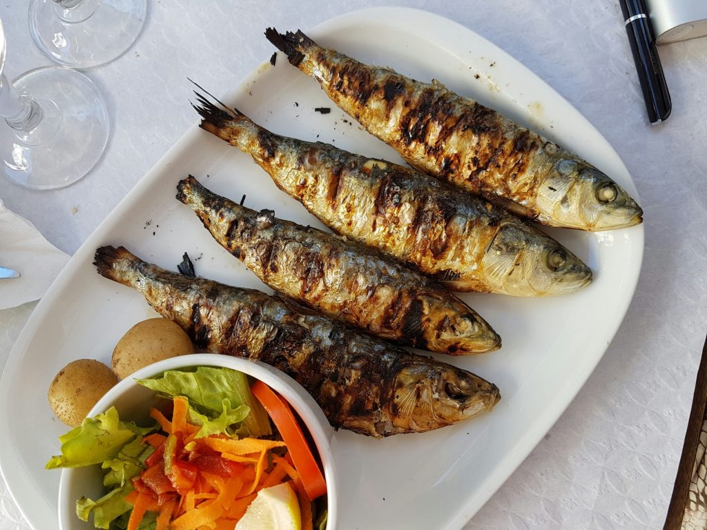 Freshly grilled sardines served beachside at Fish Shack in Ibiza with salad and potatoes