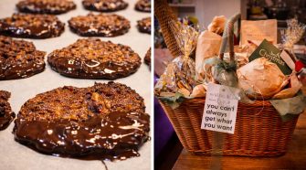 Close-up of glossy dark chocolate-dipped pecan florentines cooling on parchment, alongside a luxurious Fortnum & Mason-inspired Christmas hamper wrapped with ribbon, festive packaging, and handwritten gift tags.