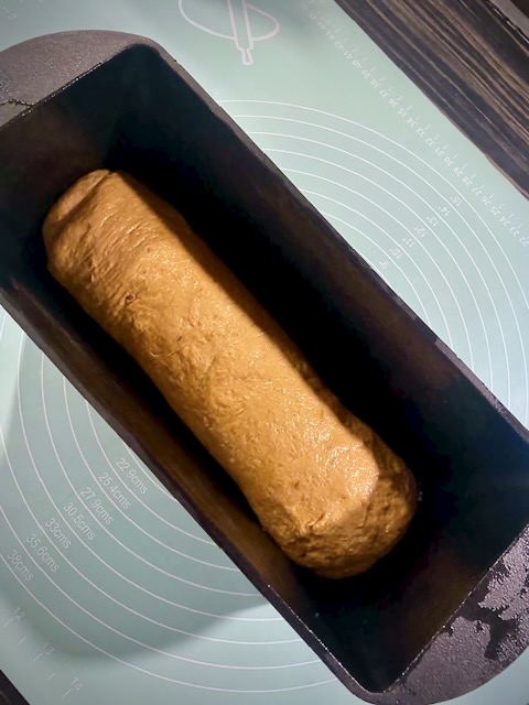 Polish rye bread dough shaped and resting in a loaf tin before baking