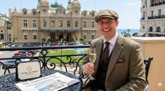 Yorkshire traveller enjoying champagne on a balcony overlooking Hôtel de Paris and Casino Square in Monte Carlo during a luxury weekend in Monaco.