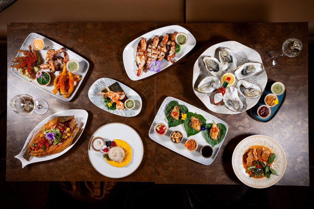 An overhead view of dishes at Sukhothai South Parade in Leeds including oysters, prawns, seafood starters, curry and dessert