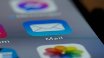 Close-up of a smartphone screen showing the Mail app icon, representing email organisation, inbox management and digital communication while travelling.