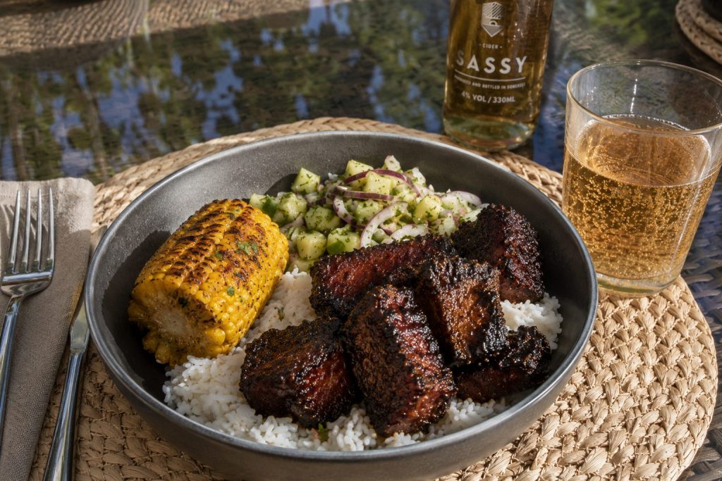 Jerk pork belly burnt ends with pineapple chow, coconut rice and rum-glazed corn