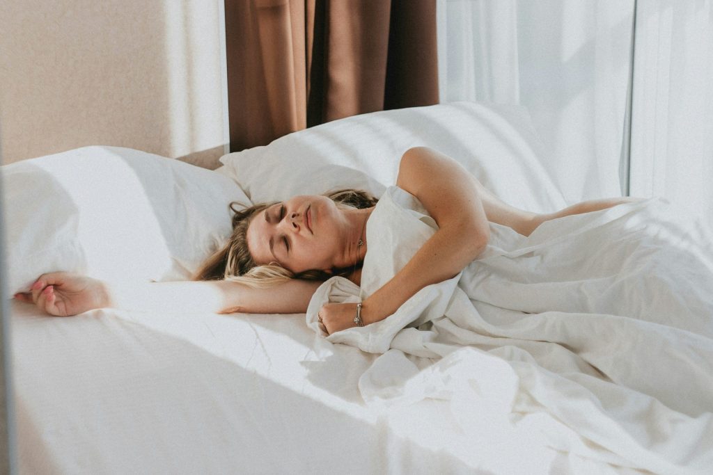 Lady sleeping in bed with white sheets