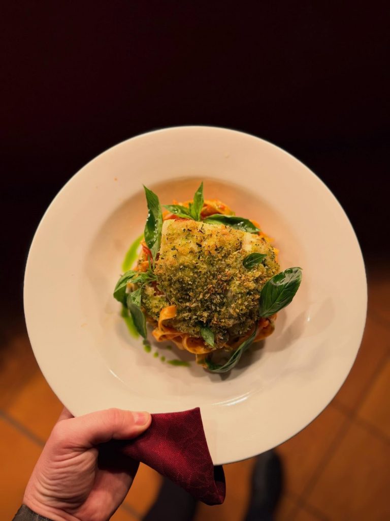 A plated pasta dish with herbed crumb fish, basil and tomato sauce served at Kendells Bistro in Leeds, ideal for a first date restaurant feature.
