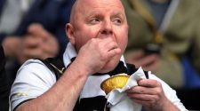 Football supporter eating a matchday pie