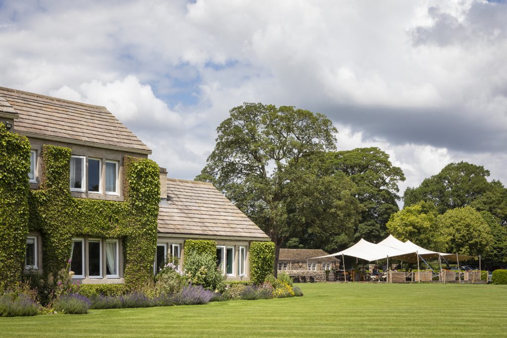 Exterior of The Devonshire Arms Hotel and Spa with landscaped gardens and Brasserie terrace in the Yorkshire Dales.