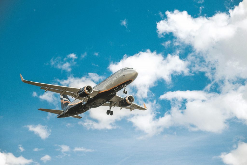 Large aircraft in the blue sky with clouds