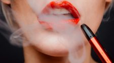 Woman with red lipstick with a vape