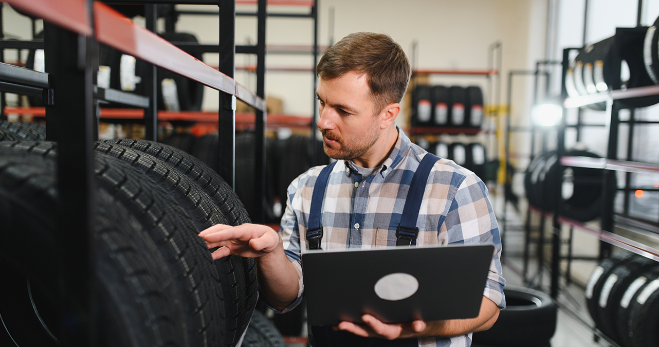 Tyre technician inspecting a budget tyre at a local fitting centre