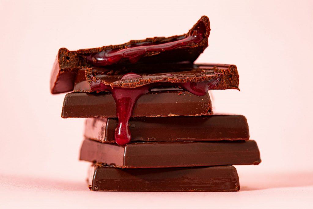 A stack of chocolate with a red cherry filling