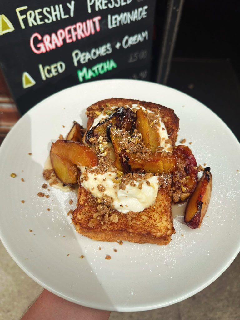 Golden French toast topped with peach slices, cream and a crumb topping at House of Koko Leeds