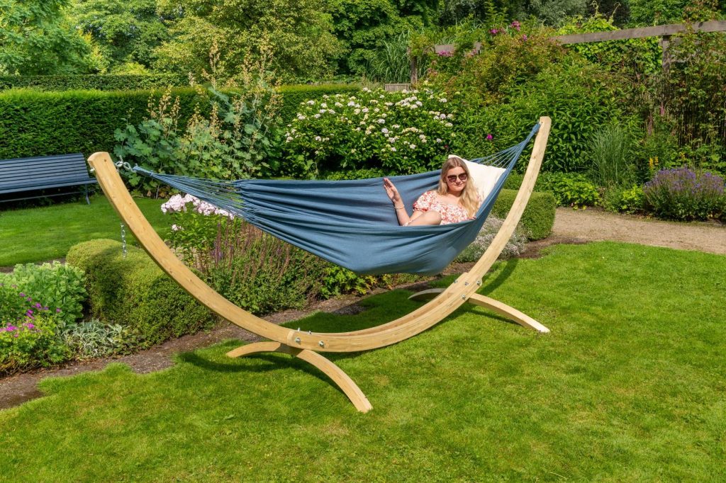 Person relaxing in a hammock in a summer garden