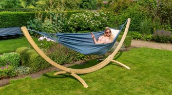 Person relaxing in a hammock in a summer garden