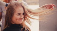 Woman having her hair styled for a blonde hair extensions transformation