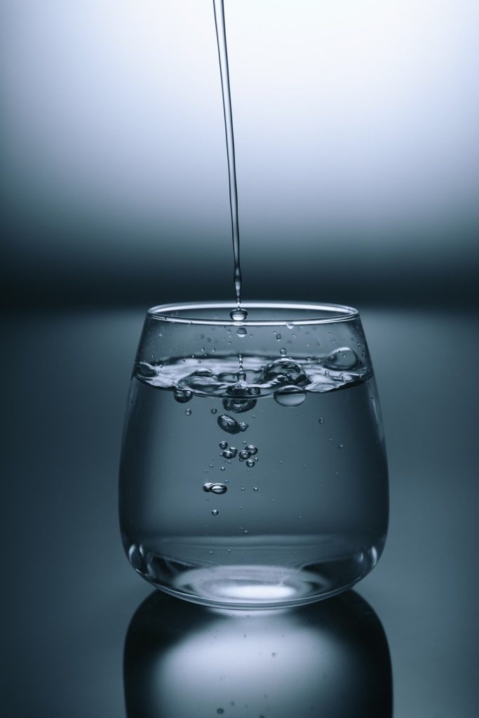 Water pouring into a clear drinking glass