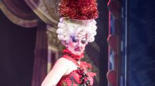 Drag performer in a red costume on stage during a cabaret show