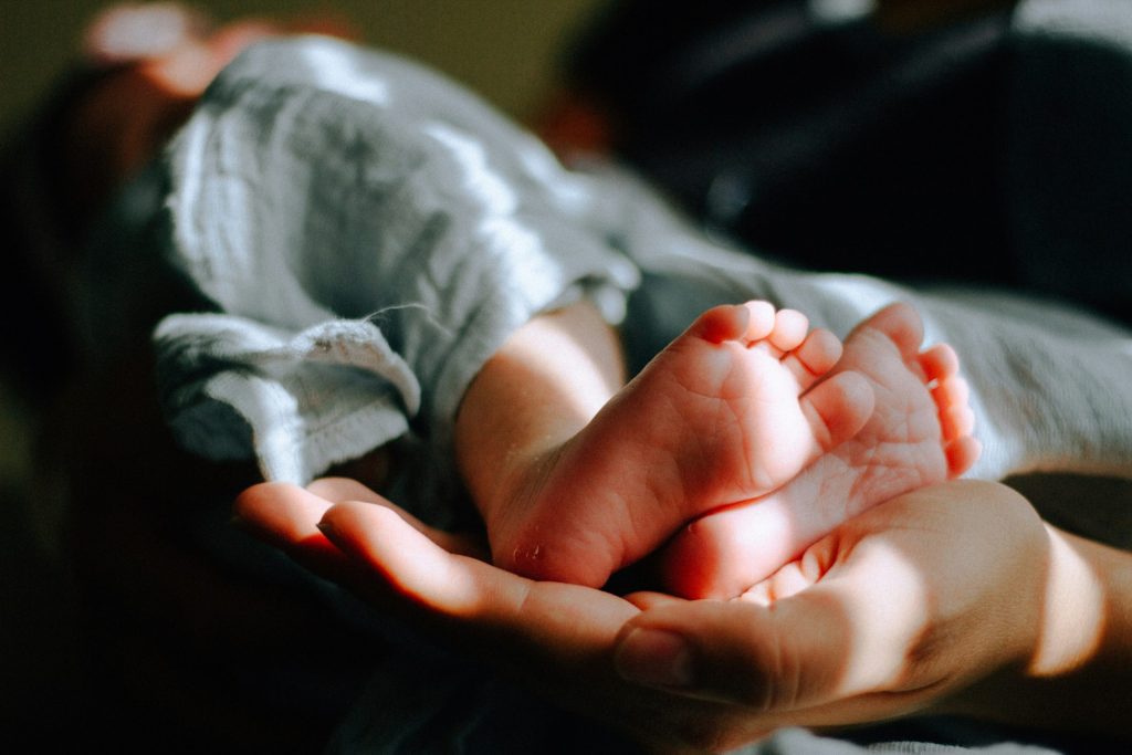 Close-up of a baby's feet resting in an adult's hands