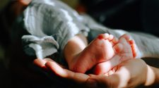 Close-up of a baby's feet resting in an adult's hands