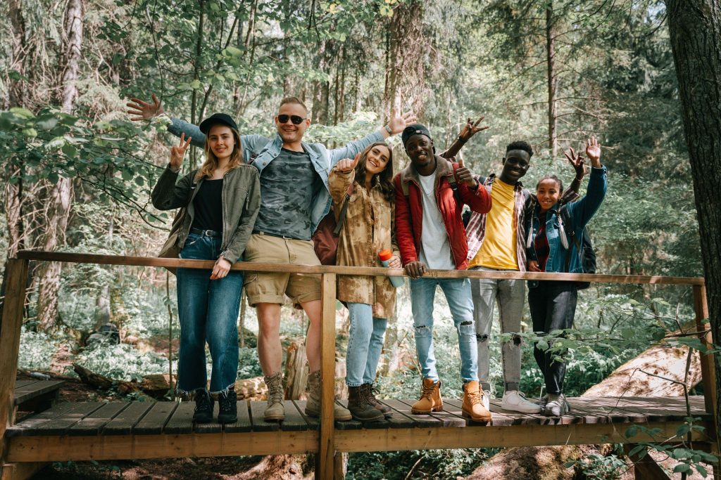 Six friends posing on a wooden bridge in a forest