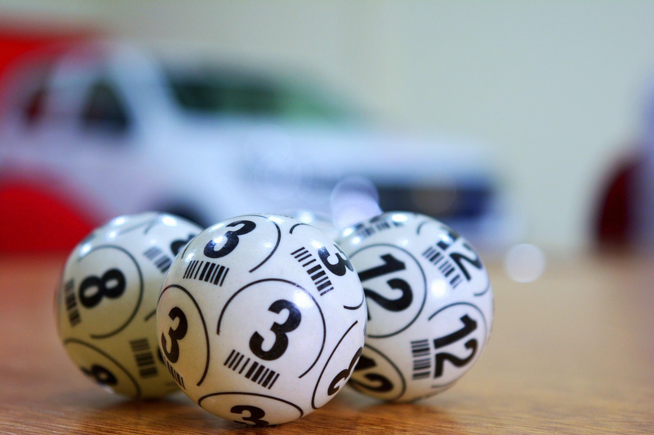Three numbered white bingo balls resting on a wooden table